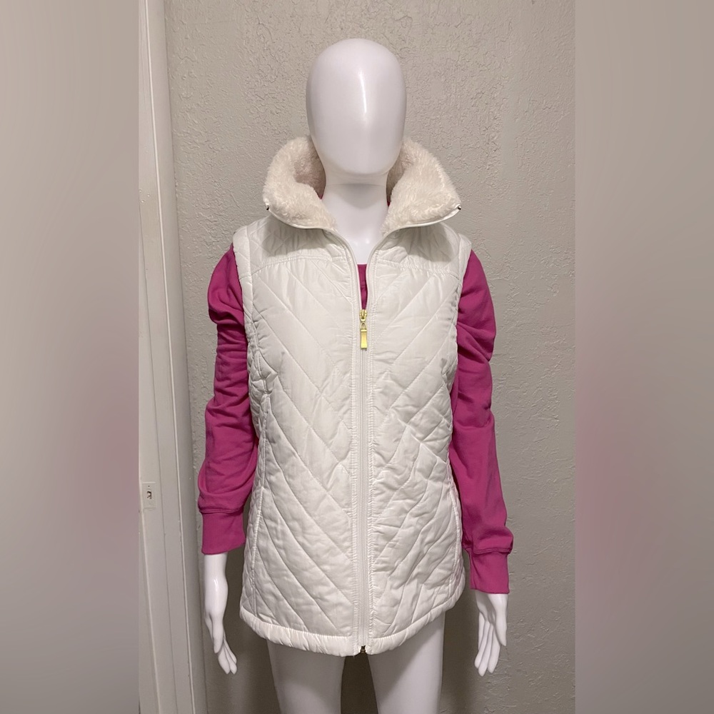 White puffer vest. Gold zipper.